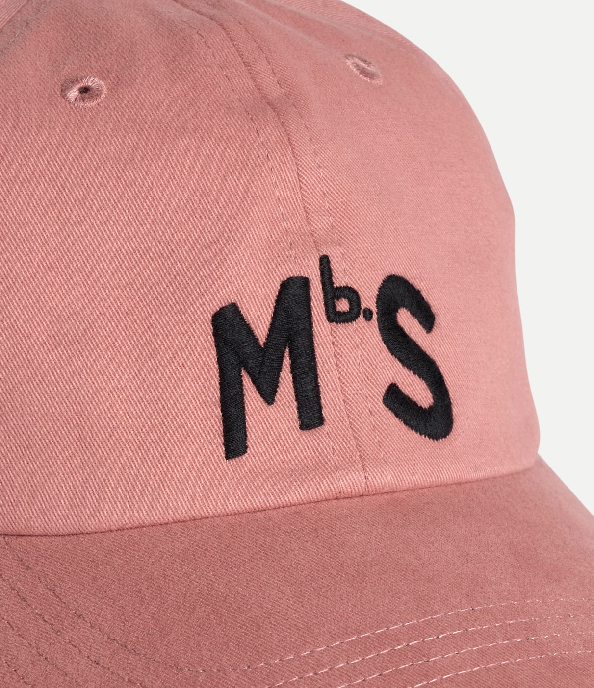 Pink cap with black 'MbS' logo on a light gray background