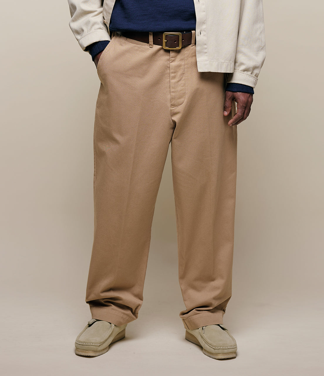 Person wearing beige chinos with a plain background