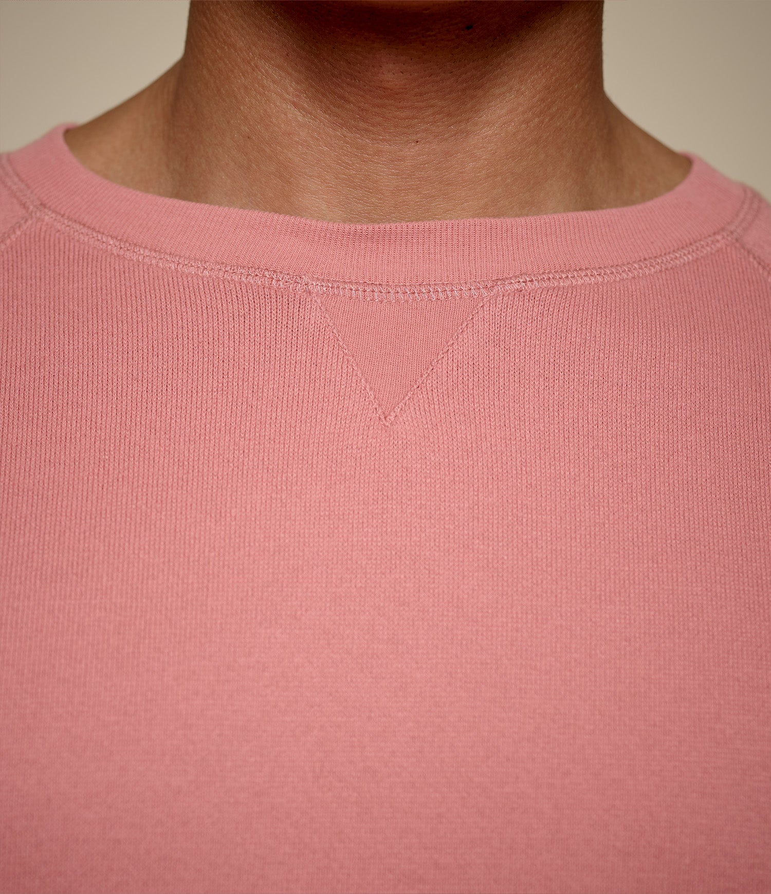 Close-up of a pink sweatshirt with a neutral background