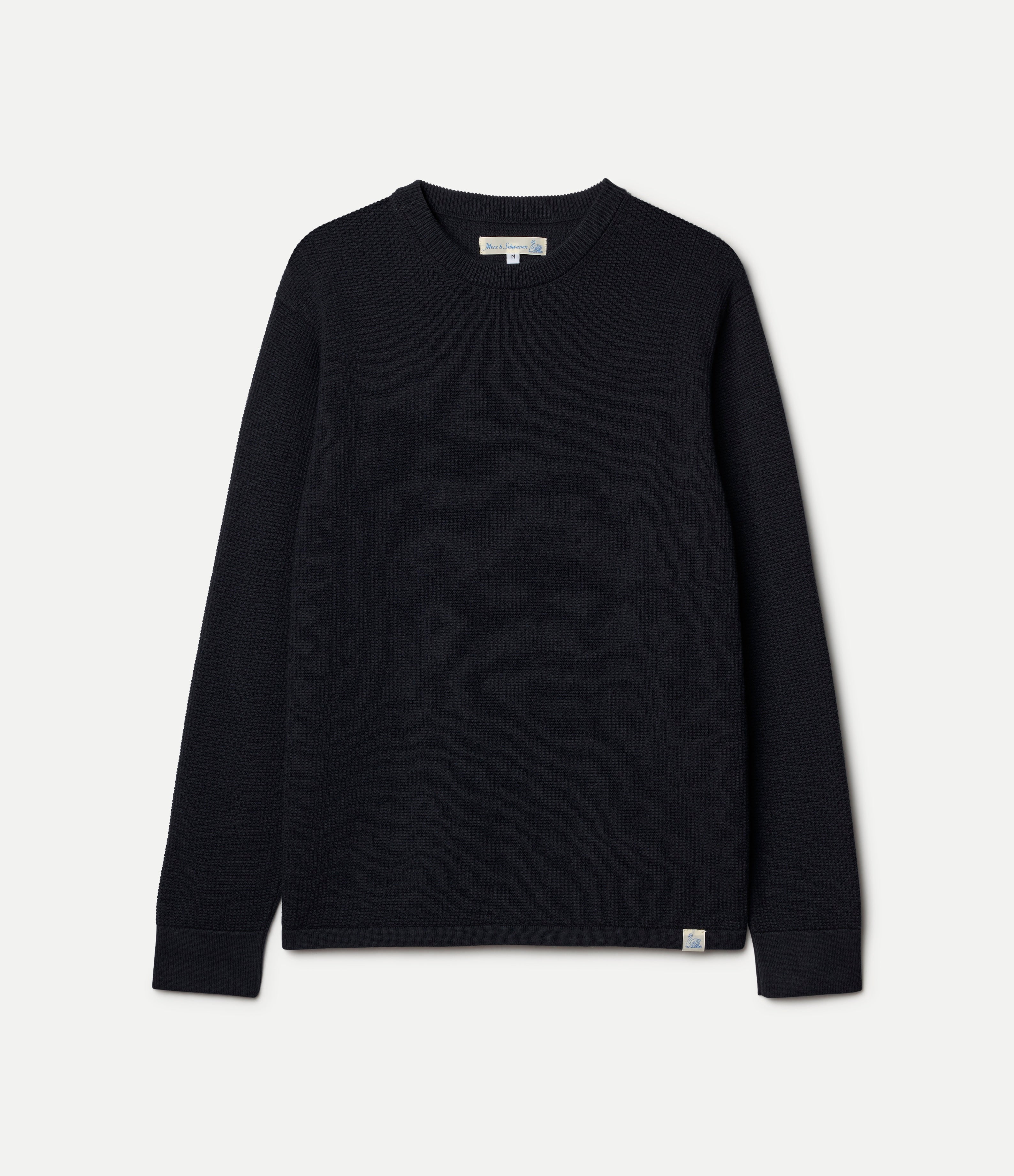 A navy textured lightweight sweater with long sleeves, shown from the back against a light gray background.