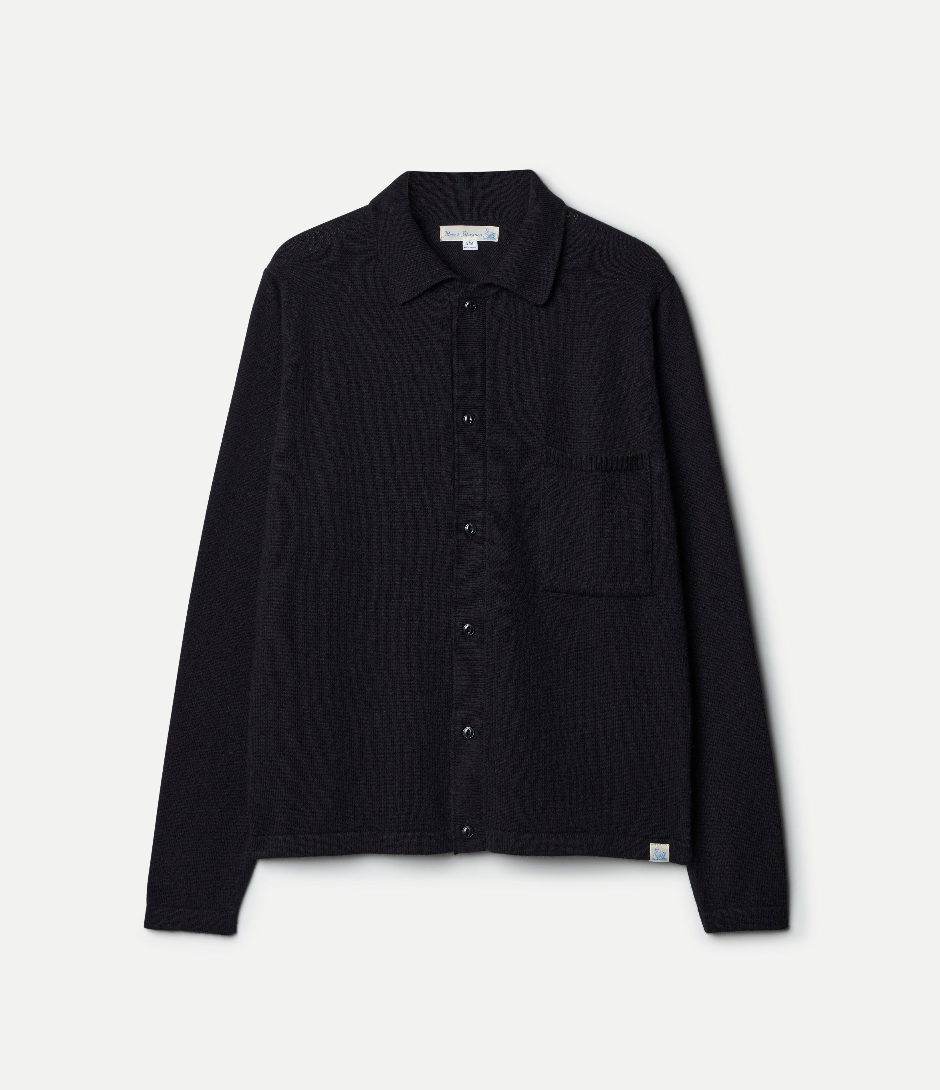 Black knitted shirt with a pocket on a light gray background
