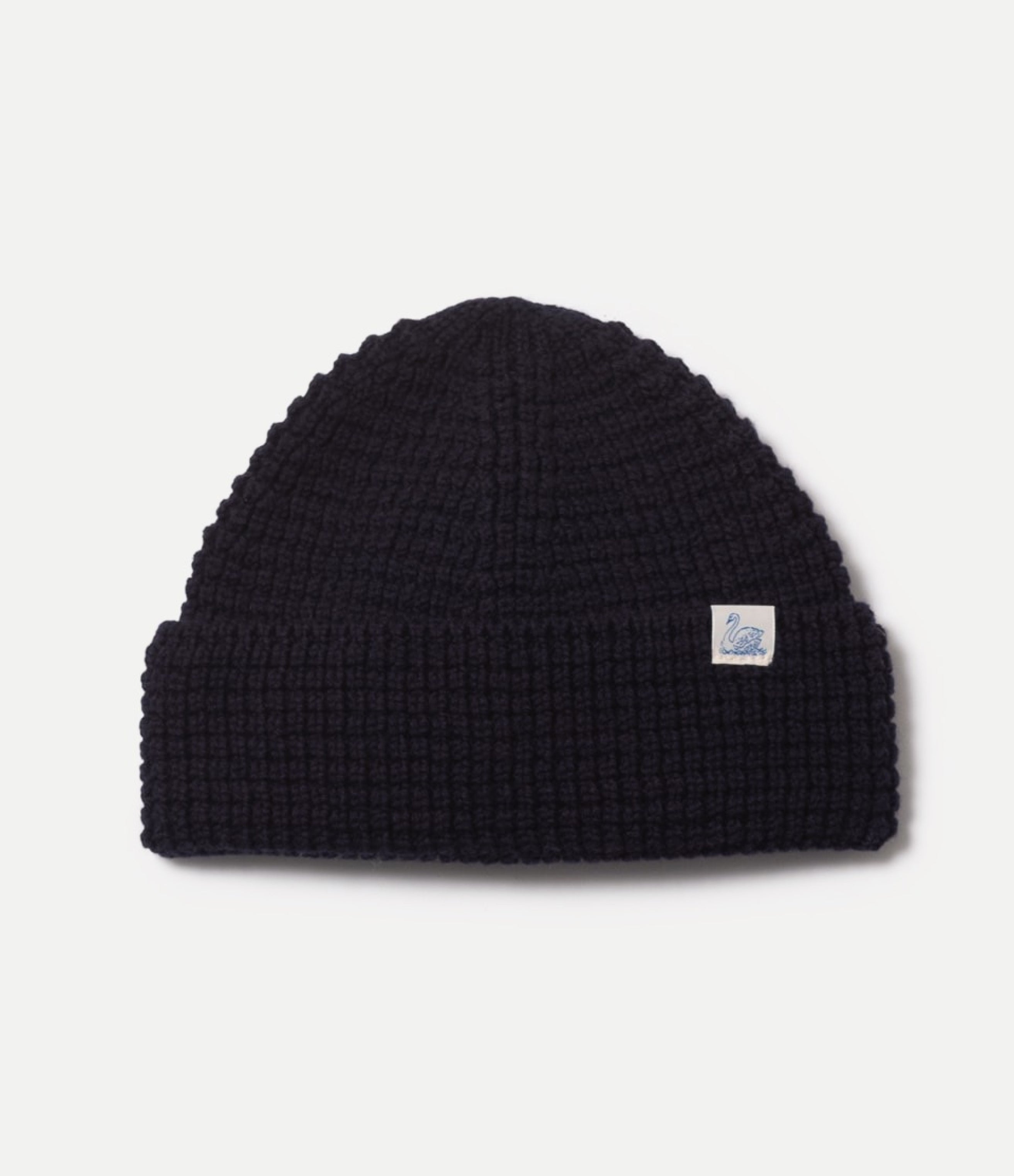 Blue waffle knit beanie with a small logo on a light gray background