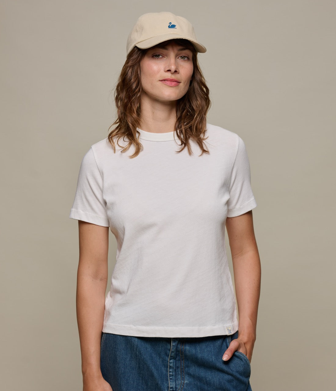 Woman wearing a white authentic jersey t-shirt and a beige cap