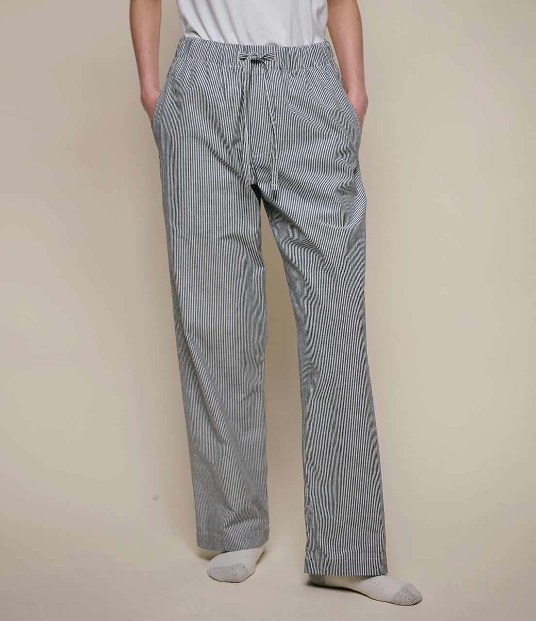 Person wearing gray checkered pants on a beige background