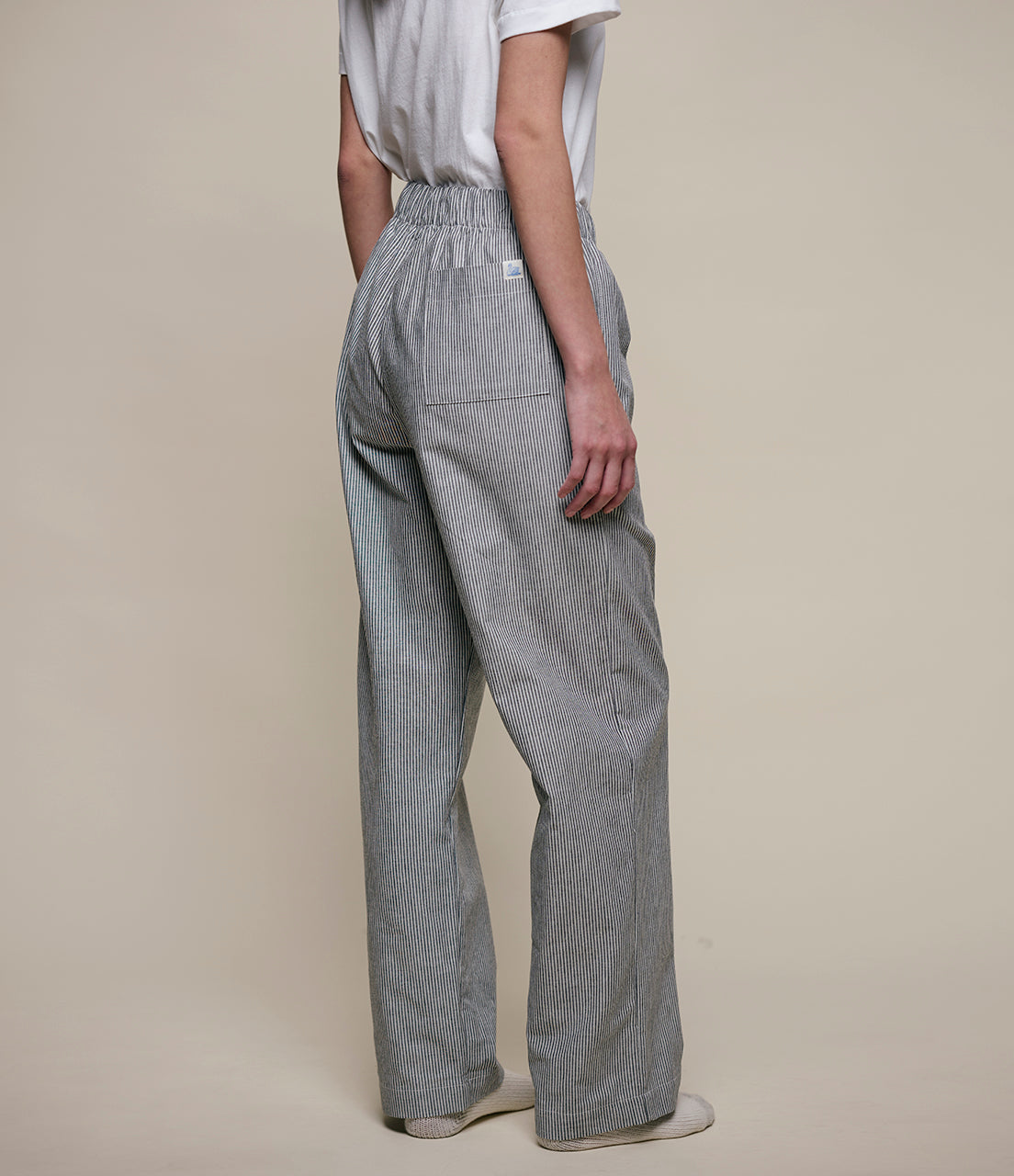 Person wearing gray checkered pants on a beige background