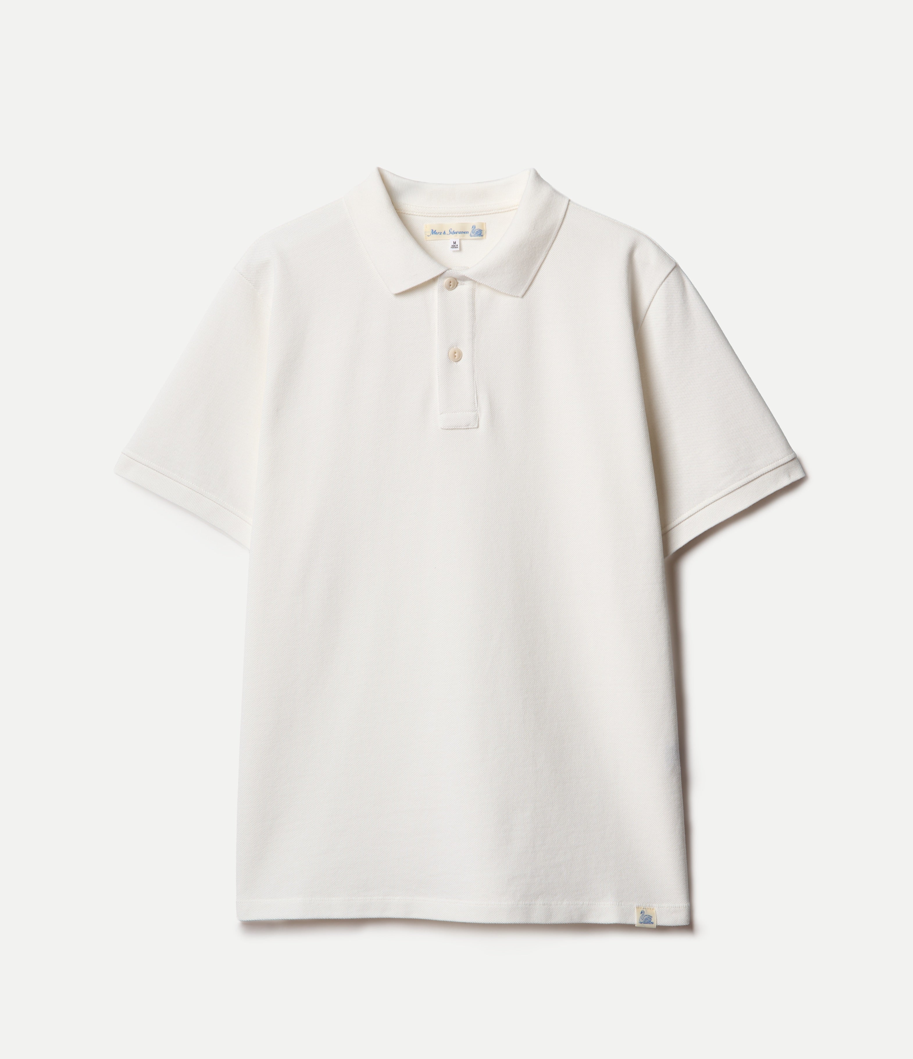 White pikée polo shirt on a light gray background