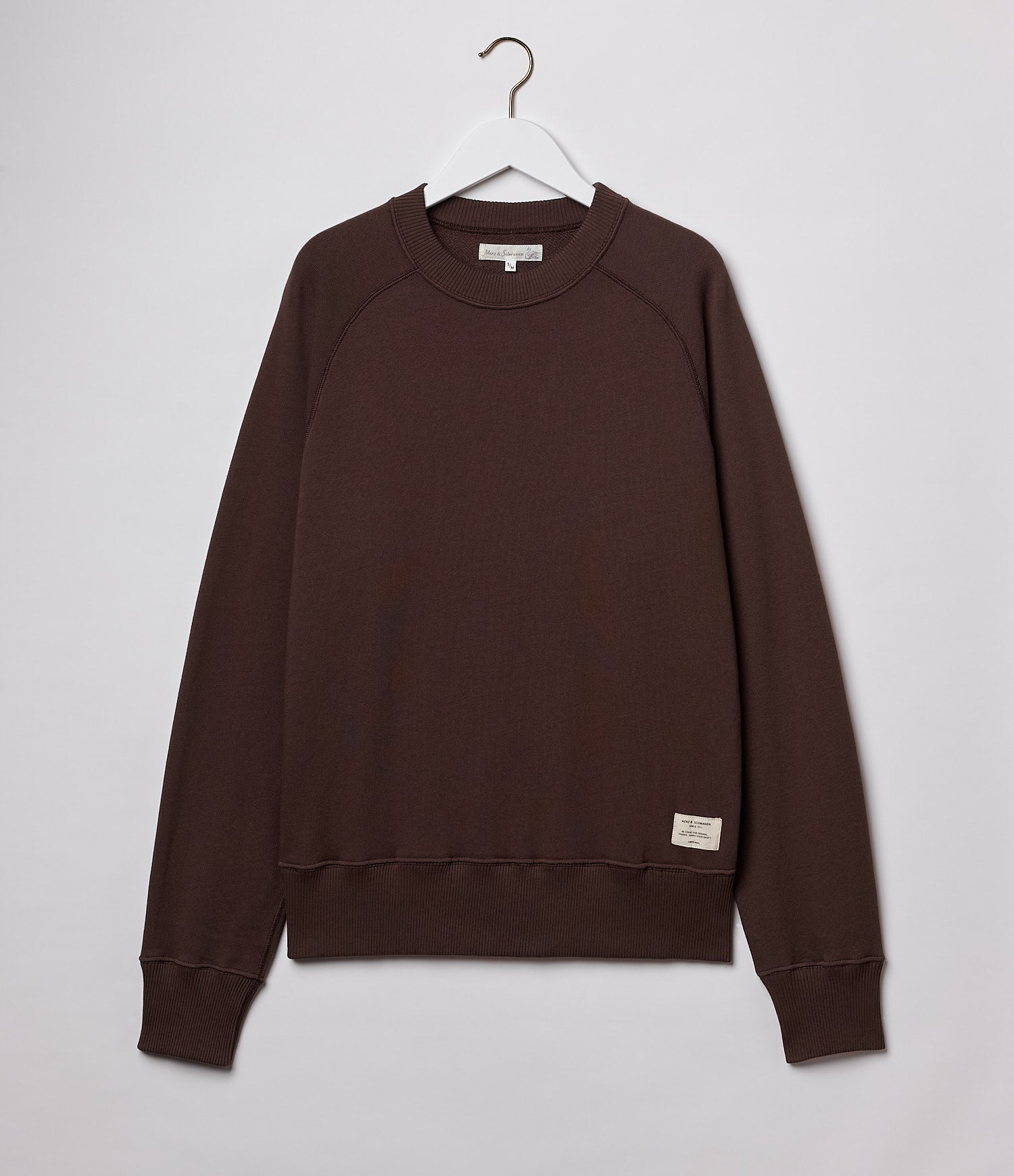 Brown sweatshirt on a hanger against a white background