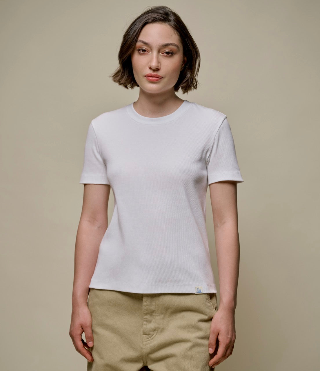 A woman wearing a white ribbed cotton T-shirt with a classic crew neck.